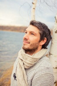 un homme heureux adossé contre un arbre regarde le ciel